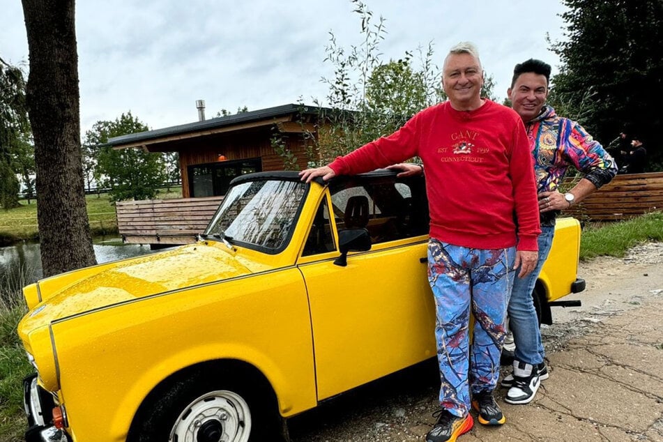 Unterwegs im gelben Trabi: Matthias Mangiapane (41, r.) und Ehemann Hubert Fella (57) bei den Dreharbeiten für "Hot oder Schrott" im September 2024.