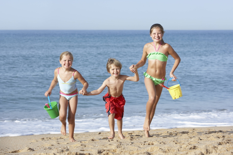 Mit dem Buddeleimer am Strand - viele Schulkinder freuen sich auf ein paar Tage Urlaubsspaß am Meer. (Symbolbild)