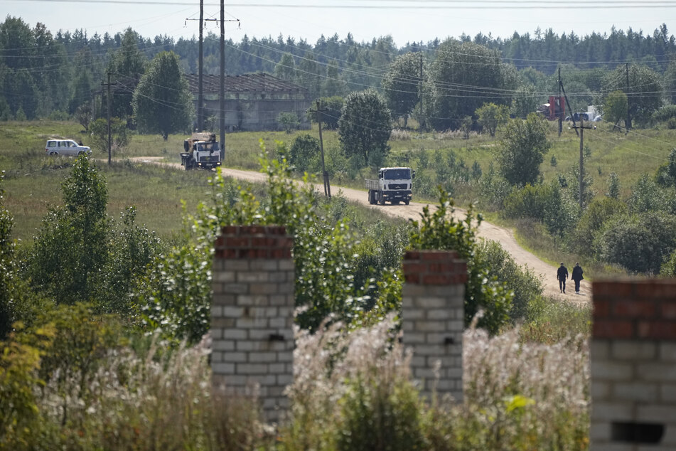 Ein Lastwagen und ein Kran-Lastwagen verlassen die Absturzstelle des Privatjets in der Nähe des Dorfes Kuschenkino in der Region Twer.