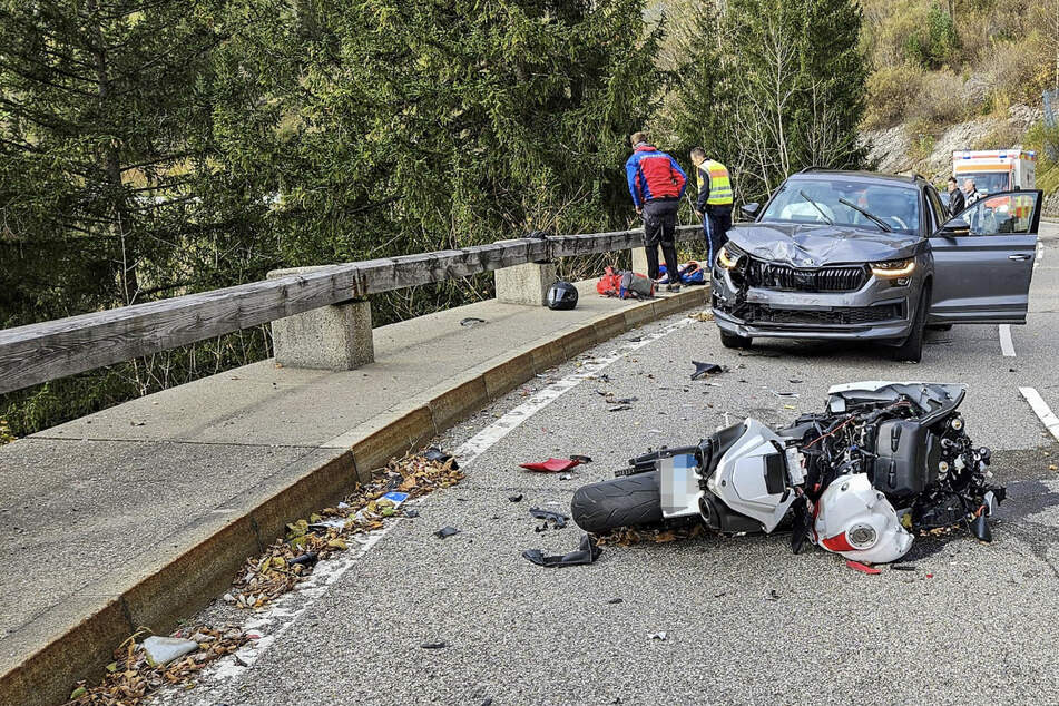 Die Unfallstelle bei Bad Hindelang: Rettungskräfte schauen über die Leitplanke in die Tiefe, wo der Motorradfahrer abstürzte.