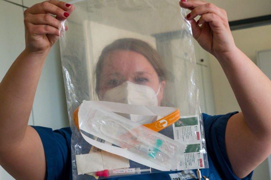 Laura Olbrich, Ärztin, zeigt die verpackte Testausrüstung.
