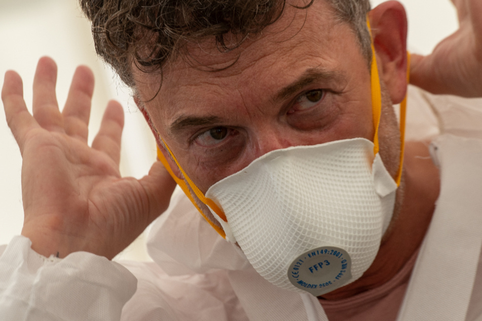 Friedrich Pürner (53), Ex-Leiter des Gesundheitsamtes, demonstriert an der Coronastation das richtige Ablegen einer Atemschutzmaske.