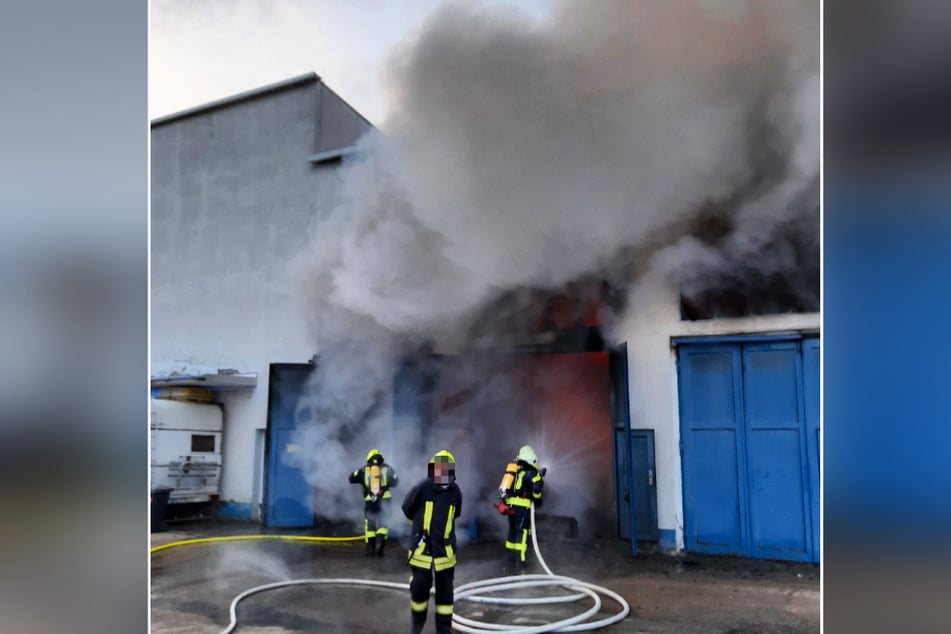 Dichter Rauch steigt aus der Lagerhalle in Limbach auf: In dem Gebäude an der Herlasgrüner Straße war am Montag ein Feuer ausgebrochen.