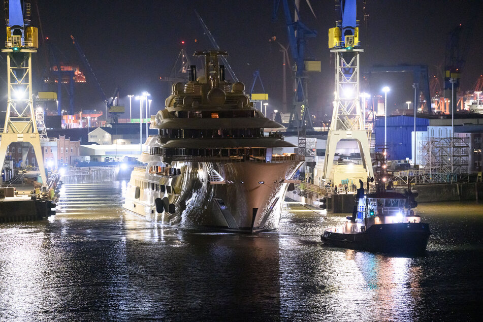 Die Luxusjacht "Dilbar" wird von Schleppern aus dem gefluteten Trockendock der Werft Blohm + Voss auf die Elbe vor den Landungsbrücken gezogen.