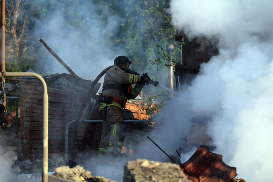 Ein Feuerwehrmann löscht einen Brand in Charkiw, der durch einen russischen Raketenangriff verursacht wurde.