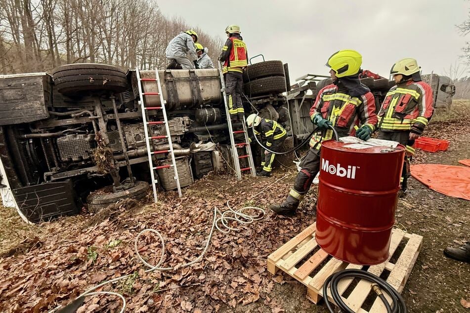 Um eine größere Umweltverschmutzung zu vermeiden, pumpt die Feuerwehr den Sprit aus dem Tank des Lasters in ein Fass.