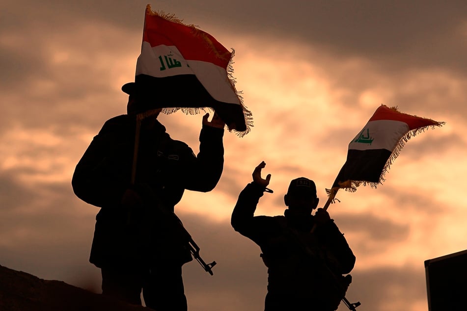 Kämpfer von Milizen im Irak, die vom Iran unterstützt werden, bekannt als die "Popular Mobilization Forces", schwenken irakische Flaggen.