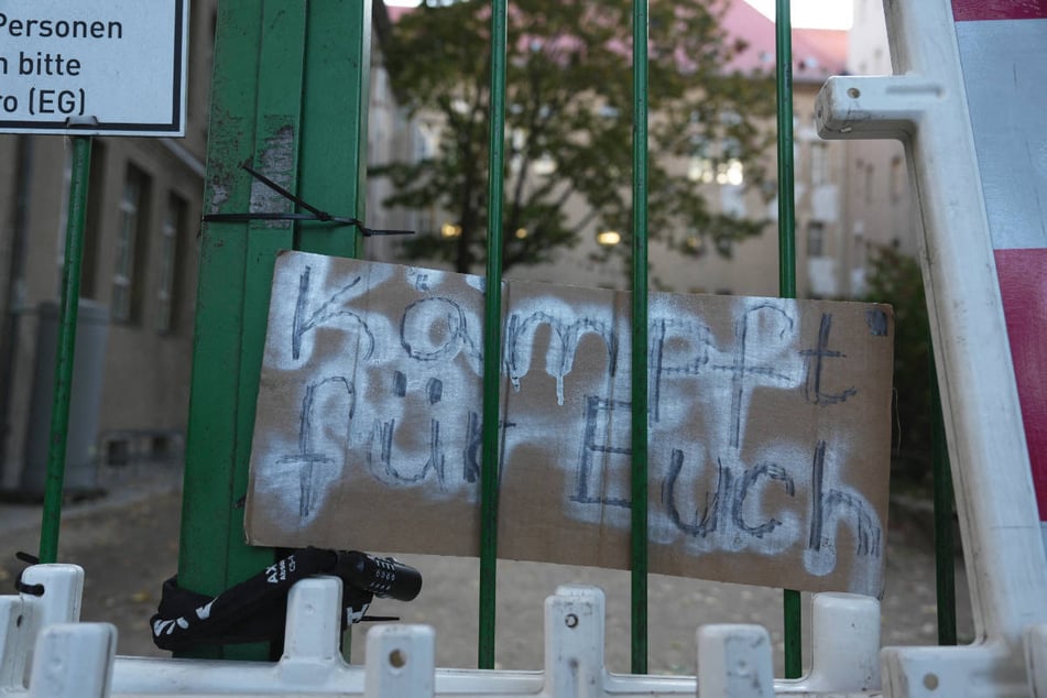 Am Zaun haben Schüler ein Plakat mit der Aufschrift: "Kämpft für Euch" befestigt.
