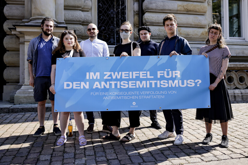 Demonstranten halten vor Beginn eines Prozesses gegen zwei Jugendliche ein Plakat mit der Aufschrift "Im Zweifel für den Antisemitismus?" in die Höhe. Die Brüder sollen im September Teilnehmer der "Mahnwache für Israel – Gegen Antisemitismus" beleidigt und angegriffen haben.