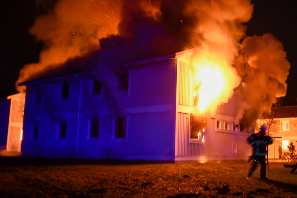 Aus den Fenstern der Notunterkunft schlagen Feuer und Rauch.