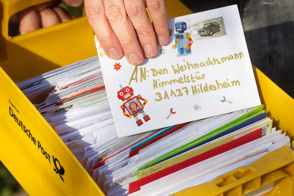 Ein Mitarbeiter vom Weihnachtspostamt Himmelsthür in Hildesheim zeigt Kinderbriefe an den Weihnachtsmann.