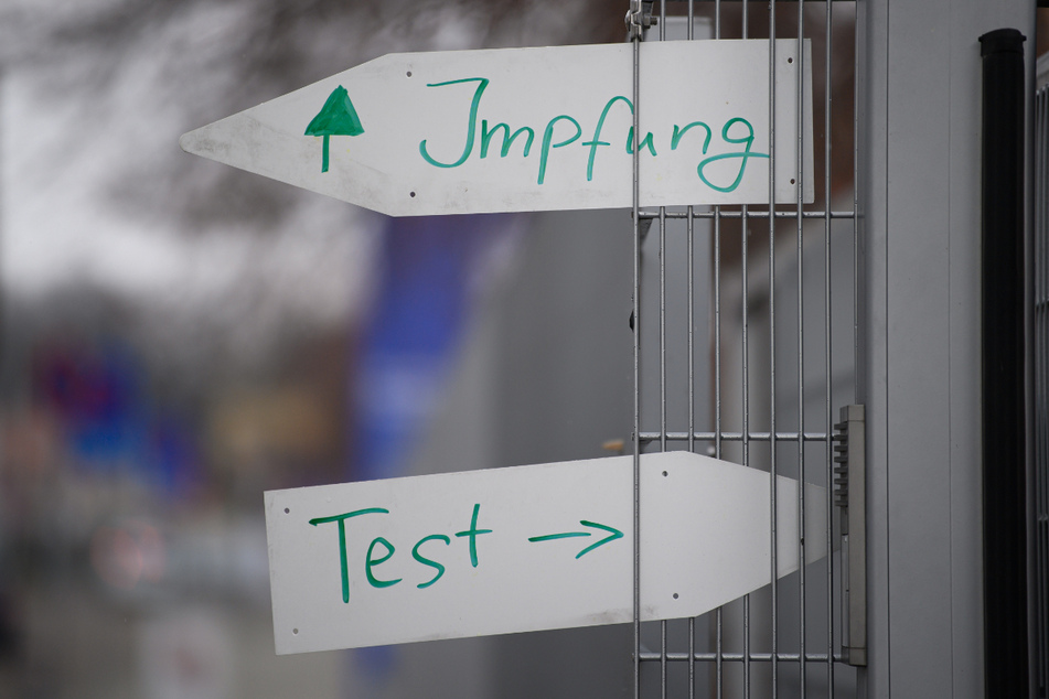Richtungspfeile mit den Hinweisen für die Impfung und für den Test sind an einem Tor an der Dresdner Messe am Corona-Testzentrum und am Impfzentrum angebracht.