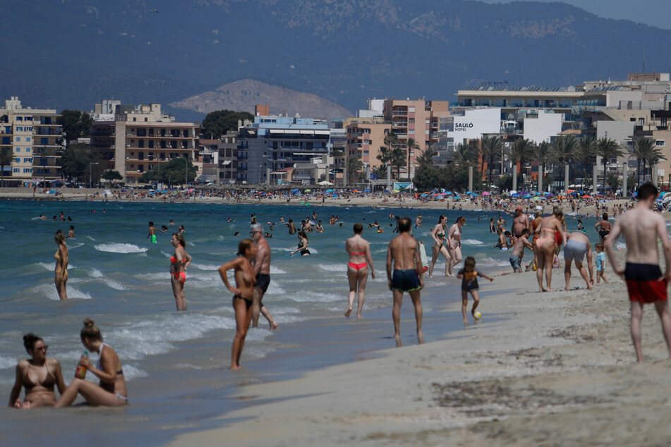 Touristen sonnen sich am Strand von Arenal. Die Maskenpflicht wurde in Spanien erheblich gelockert. Mund-Nasen-Schutz muss im Freien nicht mehr immer und überall getragen werden.