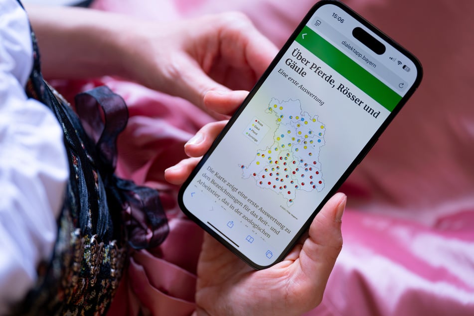 Eine Frau schaut sich auf ihrem Handy die Dialekt-App «DaBay» der Ludwig-Maximilians-Universität (LMU) an.