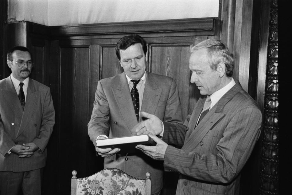 Der spätere Bundeskanzler Gerhard Schröder (heute 82, SPD, M.) trägt sich 1994 ins Goldene Buch der Stadt ein - im Beisein von Alt-OB Peter Seifert (heute 85, SPD).