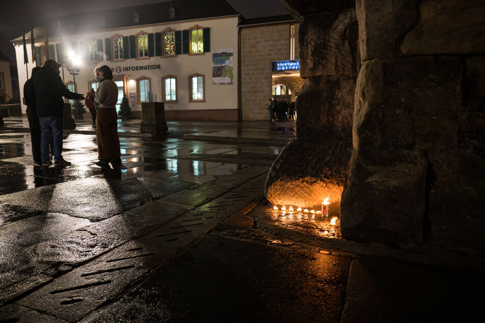 Mit Einbruch der Dunkelheit stellen Menschen in Trier Kerzen auf. An der Porta Nigra flackern kleine Teelichter.