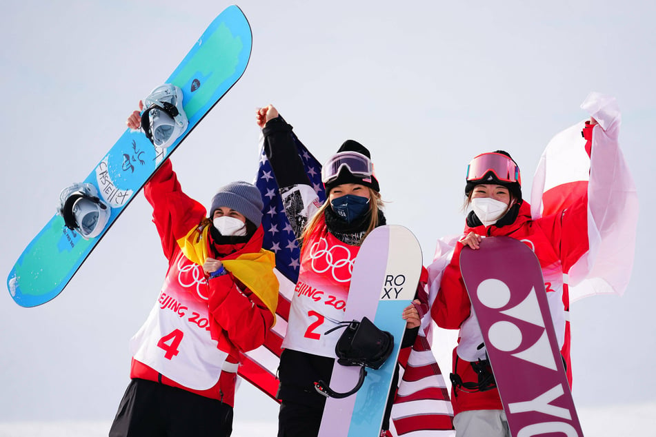 Medalists Chloe Kim (c.) of the United States, with Queralt Castellet (l.) of Spain, and Tomita Sena (r.) of Japan during the flower ceremony after the 2022 Olympic women's snowboard halfpipe final at Genting Snow Park in Zhangjiakou, China.