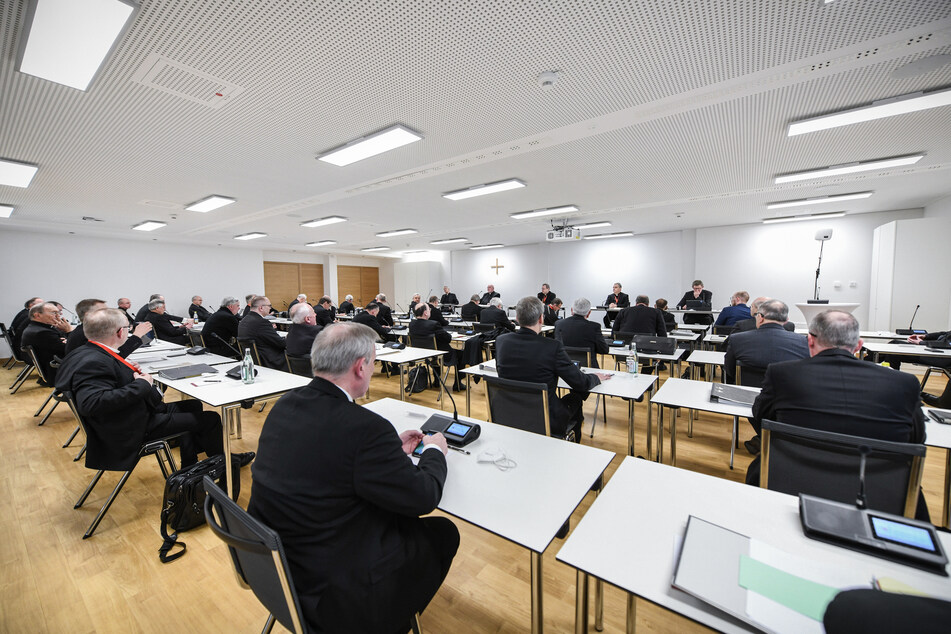 Bischöfe sitzen im Tagungsraum bei der Eröffnung der Frühjahrsvollversammlung der Deutschen Bischofskonferenz (DBK).