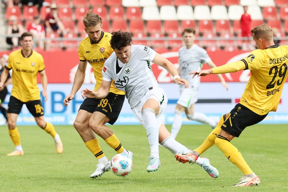 Wolfsburgs 1:0-Torschütze Jonas Wind (26, M.) behauptet sich im Zweikampf gegen Dynamos David Kubatta (21, l.).