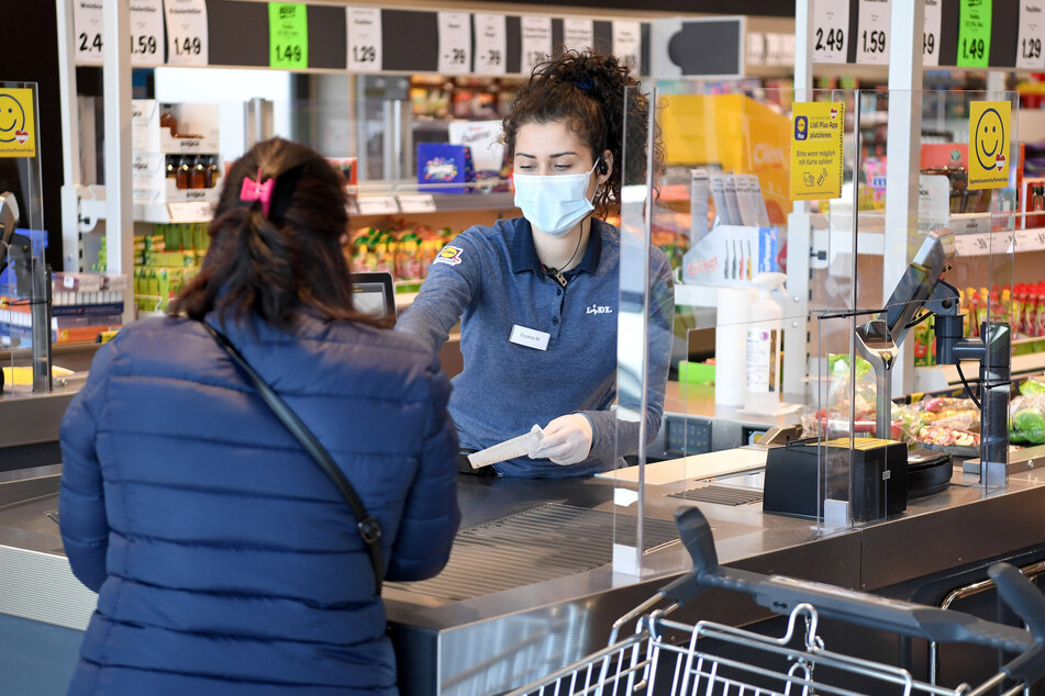 Eine Verkäuferin trägt eine Schutzmaske in einem Supermarkt.