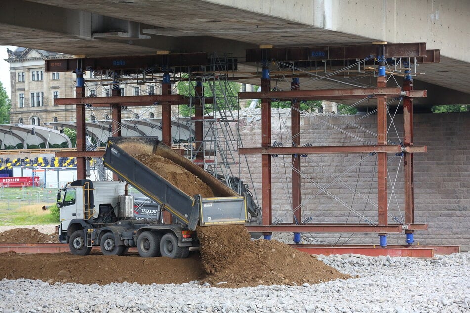 Lkw transportieren tonnenweise Kies und Erdreich auf die Baustelle: So entsteht das Fallbett für das Mittelstück.