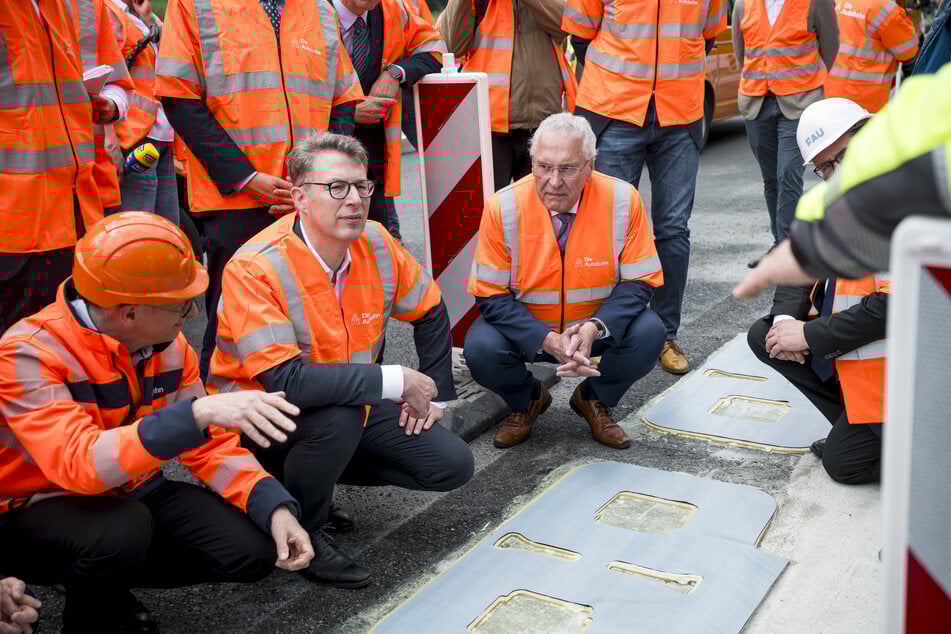 Wissenschaftsminister Markus Blume (50, CSU, 2.v.l) und Innenminister Joachim Herrmann (68, CSU, M) lassen sich die Funktionsweise des induktiven Ladens erklären.