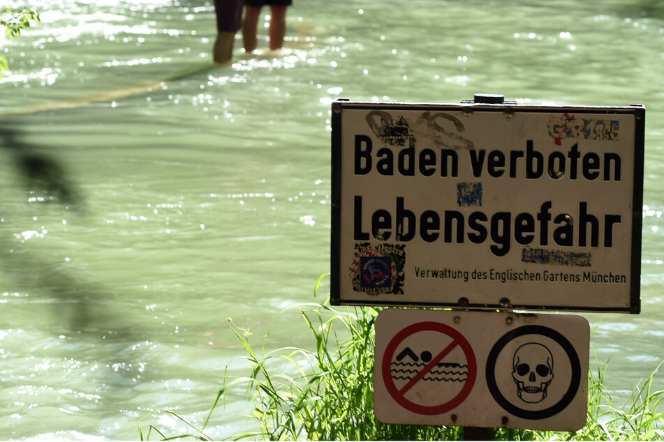 Ein Schild mit der Aufschrift "Baden verboten Lebensgefahr" weist am Ufer des Eisbachs im Englischen Garten auf die bestehende Gefahr hin.