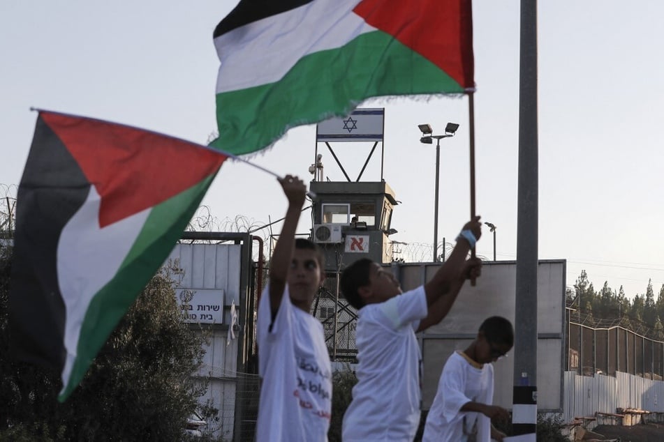 Demonstrators raise Palestinian flags during a protest outside the Megiddo prison in northern Israel.