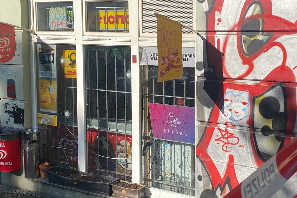 Die Einschusslöcher im Schaufenster des Kiosks in Potsdam sind nach dem Angriff deutlich zu erkennen.