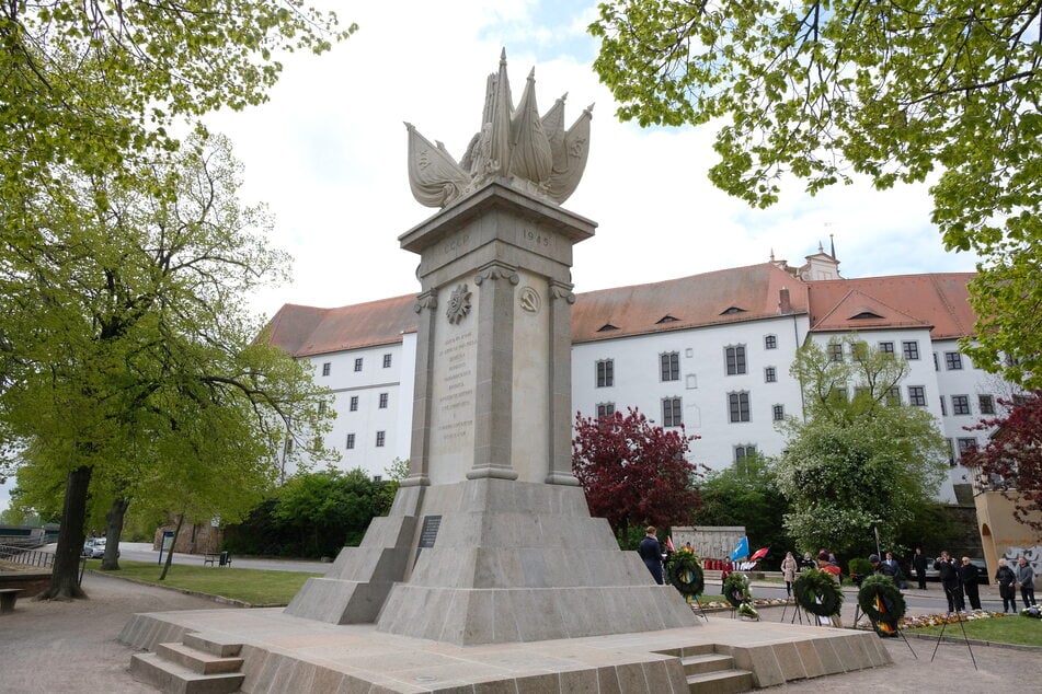 Das Denkmal der Begegnung mit Schloss Hartenfels im Hintergrund.