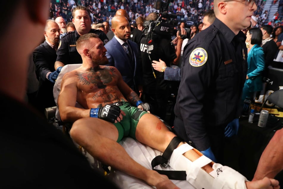 Conor McGregor leaves the cage on a stretcher after injuring his ankle in the first round of his fight against Dustin Poirier.