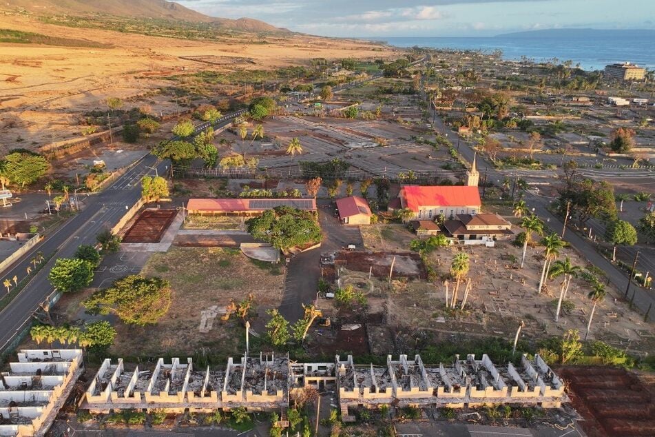 An aerial view of Maria Lanakila Catholic Church (c.), which was spared by the Lahaina fire, near a destroyed apartment building (bottom c.) on August 4, 2024.