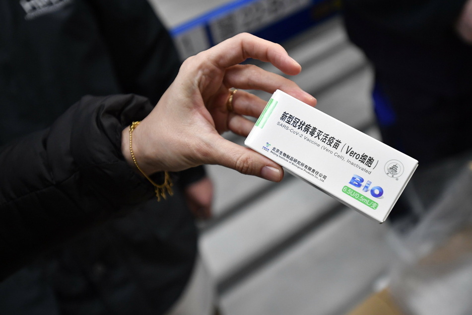 Ungarn, Budapest: Eine Frau hält ein Päckchen mit Ampullen des von Sinopharm aus China hergestellten Corona-Impfstoffs in der Hand.