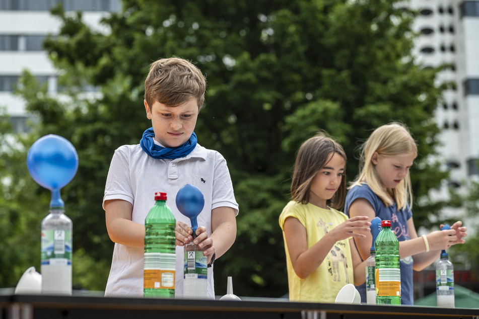 Kinder füllten bei der Mitmach-Vorlesung von Shary Reeves eine Flasche mit Backpulver und Essig und pusteten so einen Luftballon auf.