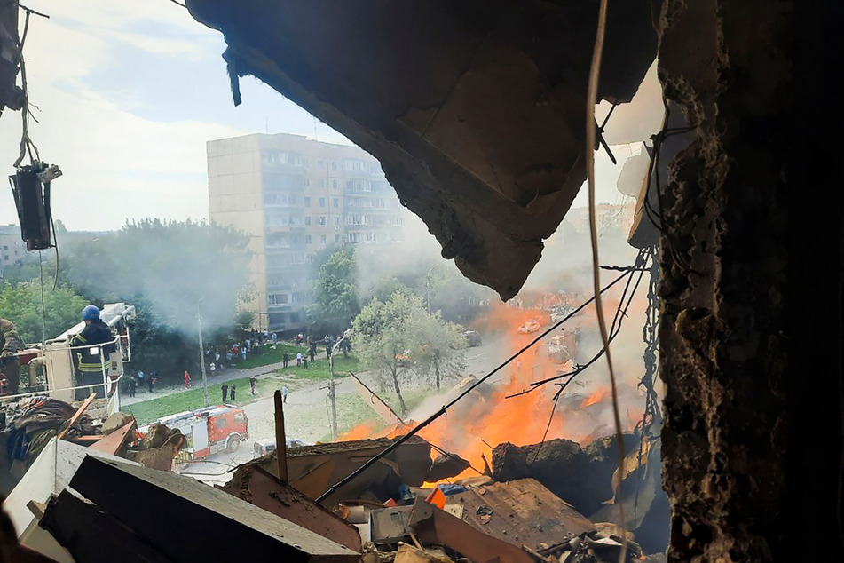 Rettungskräfte arbeiten an einem Hochhaus in Krywyj Rih, in das eine Rakete eingeschlagen ist.