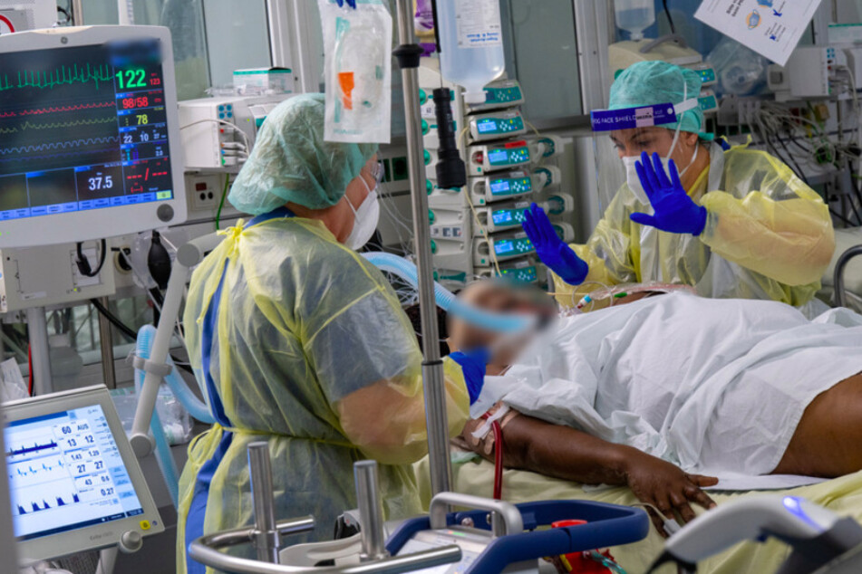 Ein Patient wird auf der Covid-19-Intensivstation des Klinikum "Rechts der Isar" von Fachkräften medizinisch betreut.