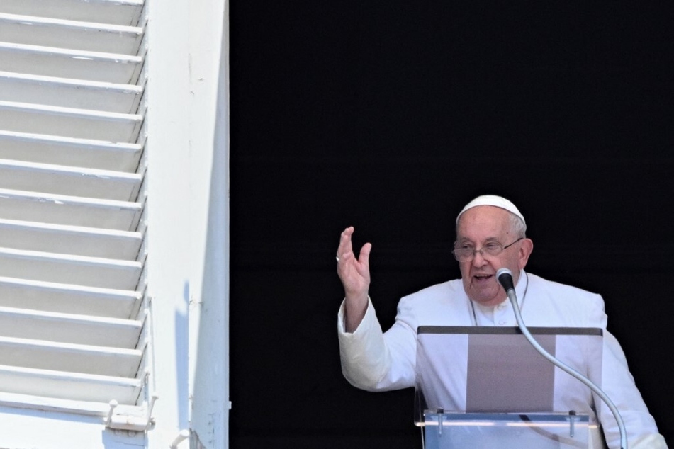 Pope Francis waves to the crowd from the window of The Apostolic Palace overlooking St. Peter's Square in The Vatican.