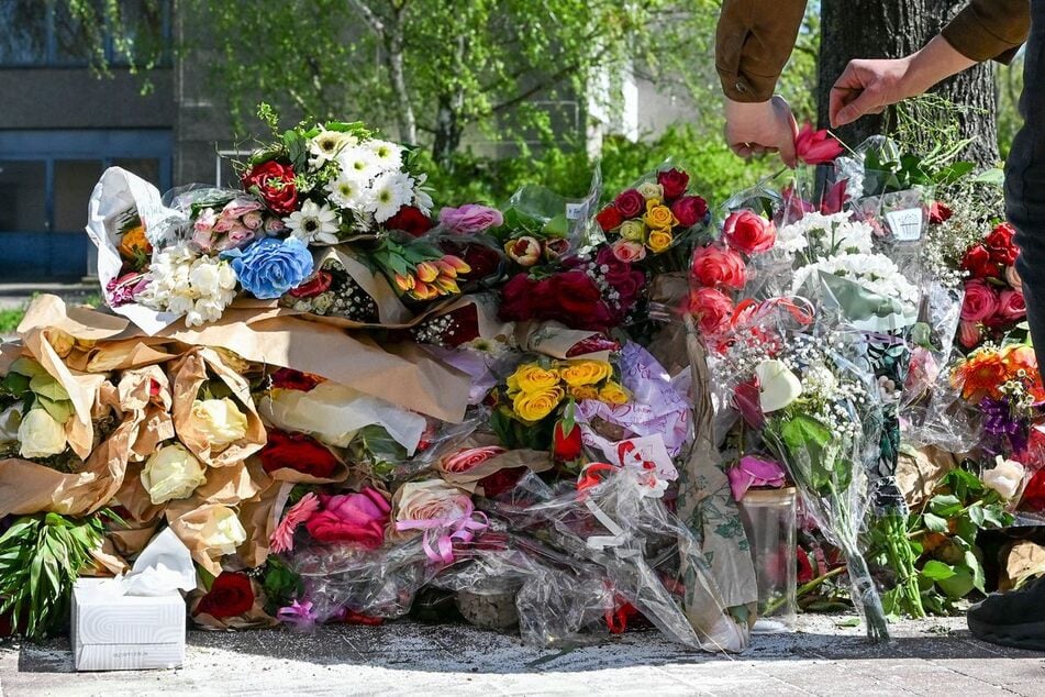 Viele Blumen sind am Ort des E-Scooter-Unfalls in Neukölln niedergelegt. Eine 14 Jahre alte Fahrerin ist nach dem Zusammenstoß mit einem Auto gestorben. Ihre gleichaltrige Beifahrerin hat schwere Kopfverletzungen erlitten.