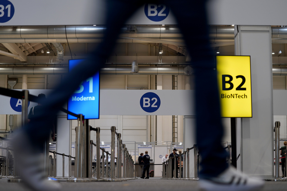 Menschen gehen ins Impfzentrum in den Messehallen.