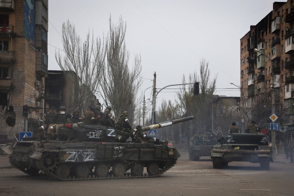 Russische Militärfahrzeuge fahren durch das zerstörte Mariupol.