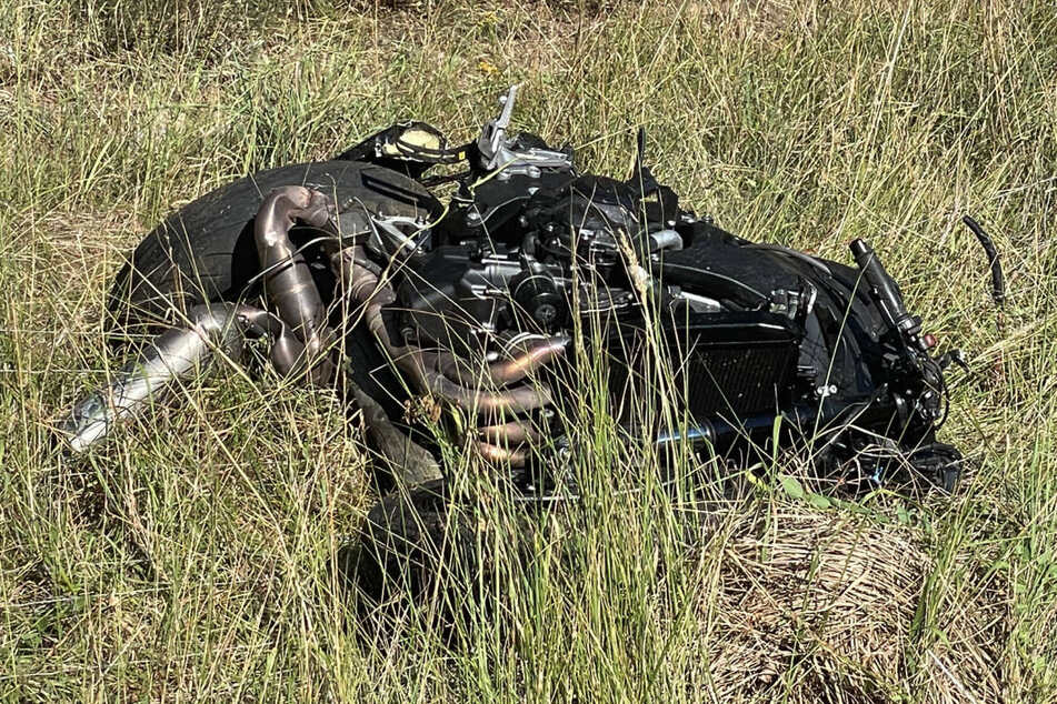 Das zerstörte Motorrad liegt nach dem Unfall im Gras neben der Autobahn.
