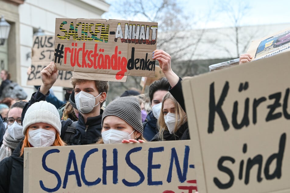 Mit Sprüchen auf großen Schildern zeigen die Studierenden ihren Unmut.