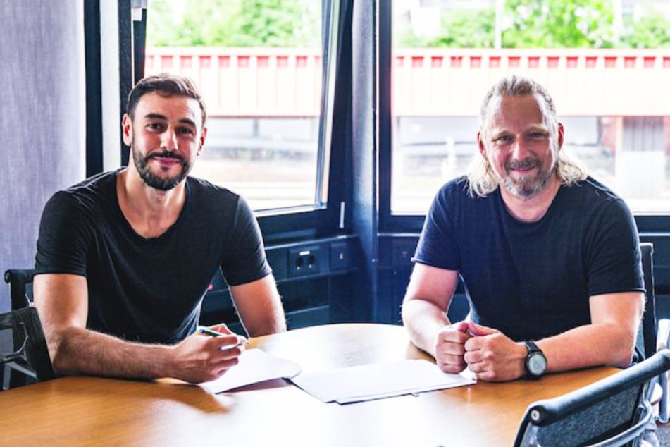 Stürmer Hamadi Al Ghaddioui (30, l.) unterzeichnet zusammen mit Sportdirektor Sven Mislintat (48) seine Vertragsverlängerung beim VfB Stuttgart.
