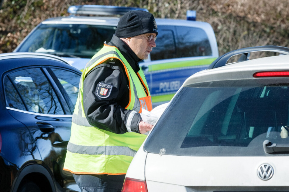 Ein Polizist kontrolliert an einer Sperre Fahrzeuge, die keine lokalen Kennzeichen haben.