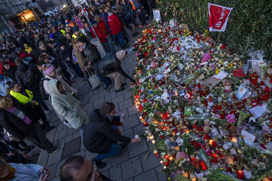 Teilnehmer der Verdi-Gedenkveranstaltung für Anschlagsopfer legen Kerzen, Blumen und Karten ab.