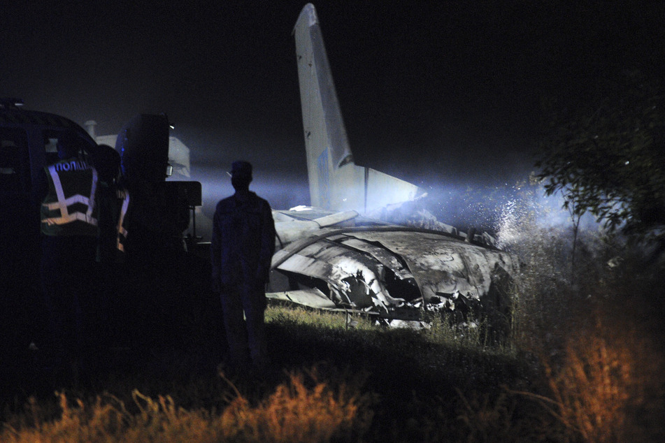 Das Wrack des Militärflugzeugs Antonow AN-26 wird von einer Lampe angestrahlt