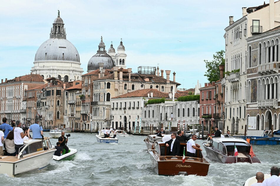 The boat Moa (r.) transporting Amazon's founder Jeff Bezos is escorted on the Grand Canal on his wedding day in Venice on Friday.