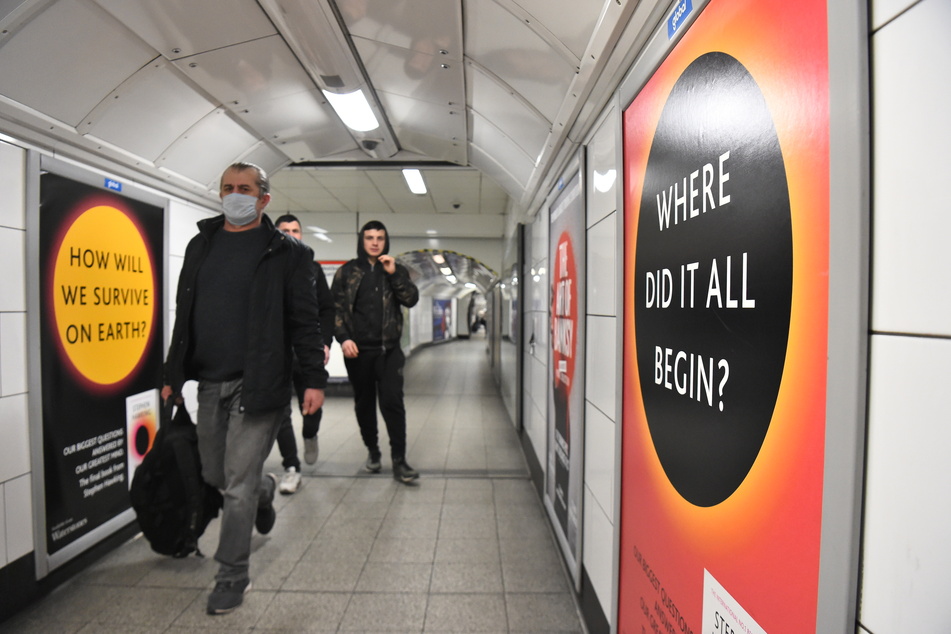Männer gehen einen Durchgang in der Londoner U-Bahn-Station "Oxford Street" entlang.