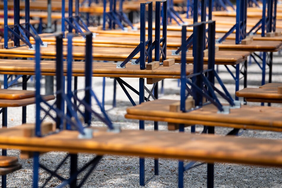 Menschenleer zeigt sich ein Biergarten mit gestapelten Bänken und Tischen.