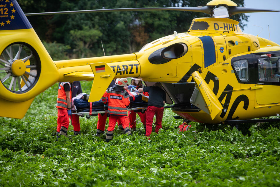 Rettungskräfte verladen eine verletze Person in einen Rettungshubschrauber.